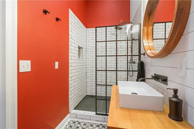 full bathroom with tiled shower and a sink