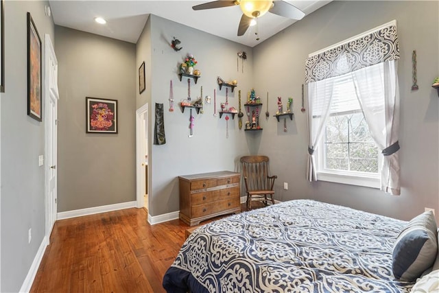 bedroom with ceiling fan, baseboards, and wood finished floors