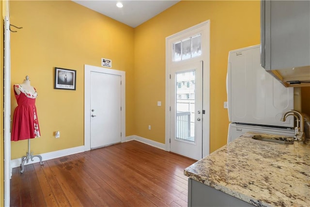 1026 Delaronde St, New Orleans, LA 70114 - kitchen with gray cabinets, a sink, light stone countertops, dark wood-style floors, and baseboards