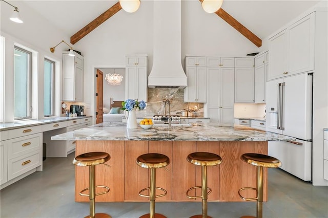 23648 Goodlife Ln, Covington, LA 70435 - kitchen featuring built in fridge, concrete floors, tasteful backsplash, beam ceiling, and high vaulted ceiling