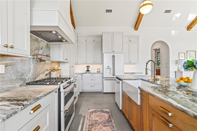 23648 Goodlife Ln, Covington, LA 70435 - kitchen with high quality appliances, premium range hood, beamed ceiling, finished concrete floors, and arched walkways
