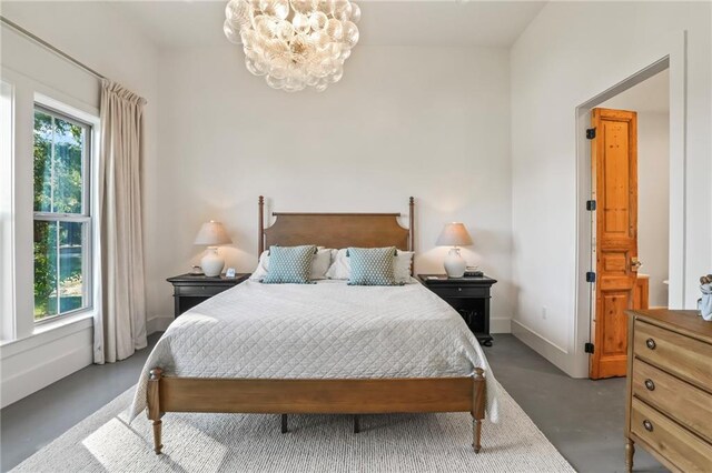 23648 Goodlife Ln, Covington, LA 70435 - bedroom with a chandelier and finished concrete floors