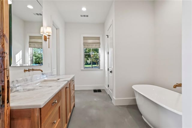 23648 Goodlife Ln, Covington, LA 70435 - bathroom with a freestanding tub, vanity, concrete floors, and recessed lighting