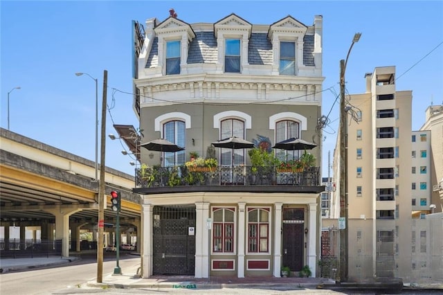 view of front of property with a high end roof and mansard roof