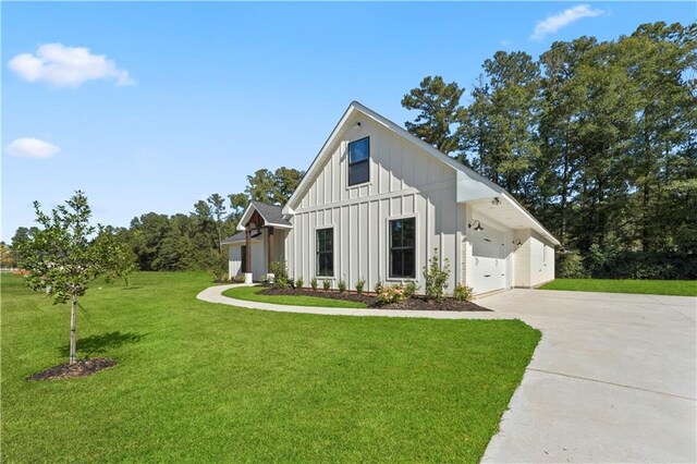 exterior space with board and batten siding, a front yard, concrete driveway, and a garage