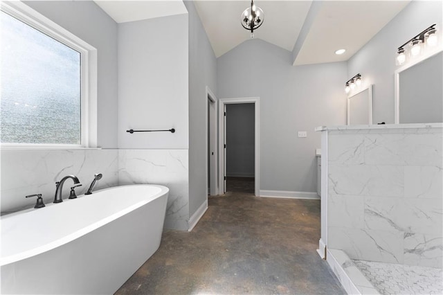 full bathroom with concrete flooring, lofted ceiling, a freestanding tub, vanity, and walk in shower