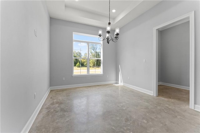 empty room featuring a tray ceiling, recessed lighting, a chandelier, concrete floors, and baseboards