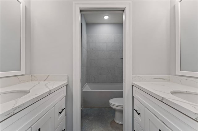 bathroom featuring two vanities, a sink, and toilet