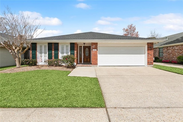 ranch-style house with an attached garage, a front yard, concrete driveway, and brick siding