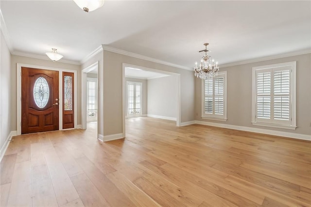 foyer entrance with ornamental molding, light wood-type flooring, and baseboards