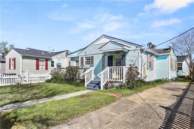 bungalow-style house featuring a front lawn and fence