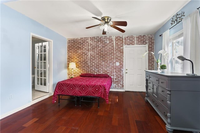 bedroom featuring brick wall, wood-type flooring, a ceiling fan, and baseboards