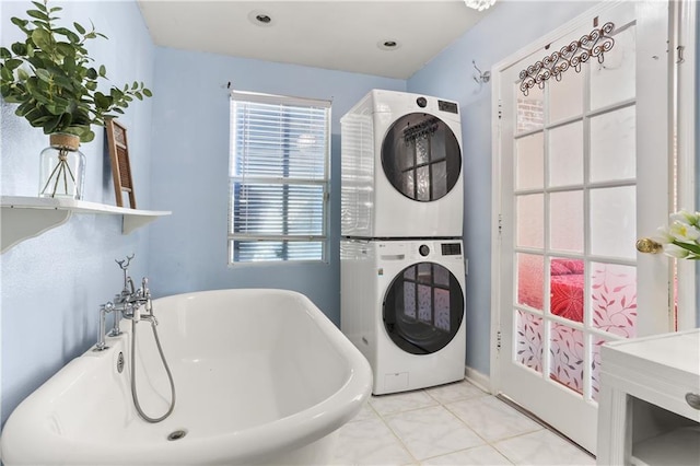 laundry area featuring stacked washer / dryer, laundry area, and tile patterned flooring