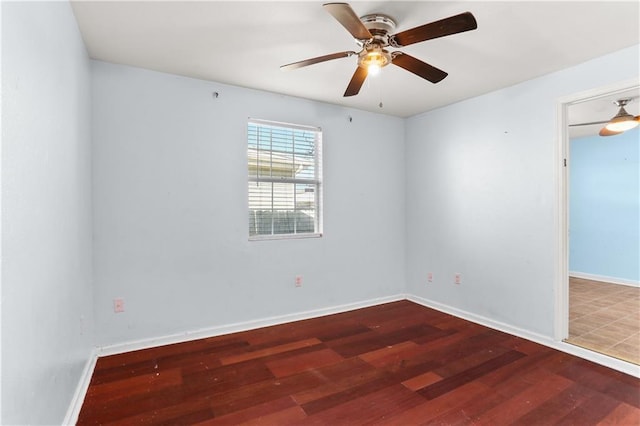 spare room featuring ceiling fan, baseboards, and wood finished floors