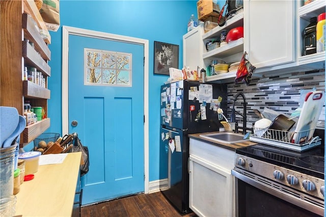 kitchen with electric range, a sink, freestanding refrigerator, open shelves, and tasteful backsplash