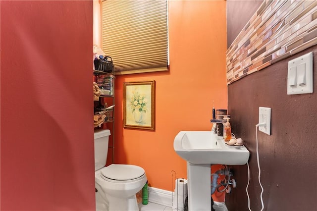 bathroom with toilet and baseboards