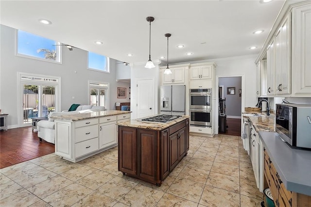 kitchen with crown molding, stainless steel appliances, recessed lighting, a kitchen island, and a sink