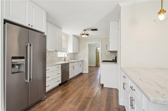 kitchen with dark wood finished floors, white cabinetry, stainless steel appliances, and a sink