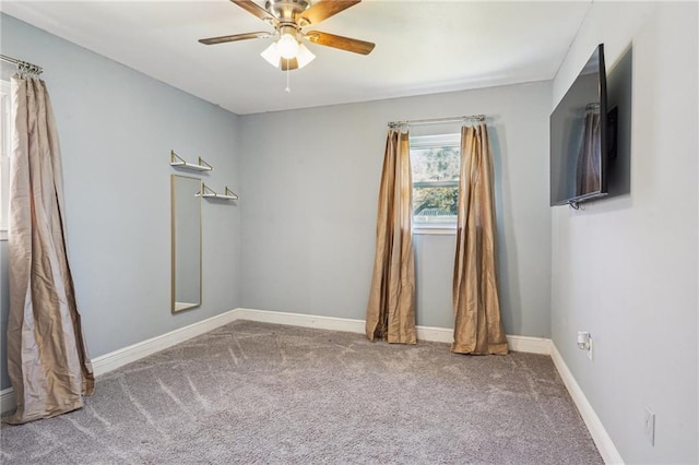 carpeted spare room with baseboards and a ceiling fan