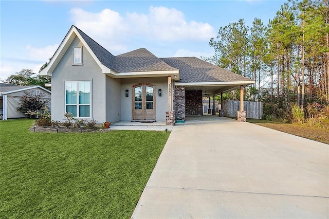 view of front of property with a front yard, roof with shingles, stucco siding, concrete driveway, and french doors