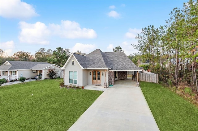 view of front facade featuring a front yard, fence, driveway, stucco siding, and a shingled roof