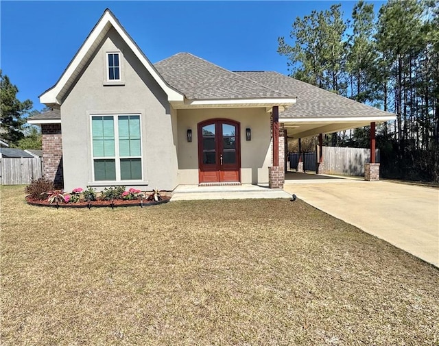 view of front of home featuring an attached carport, fence, stucco siding, concrete driveway, and french doors