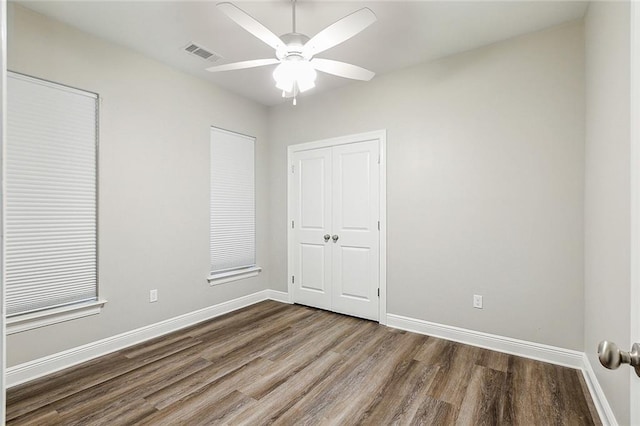 unfurnished bedroom with visible vents, baseboards, a closet, and wood finished floors