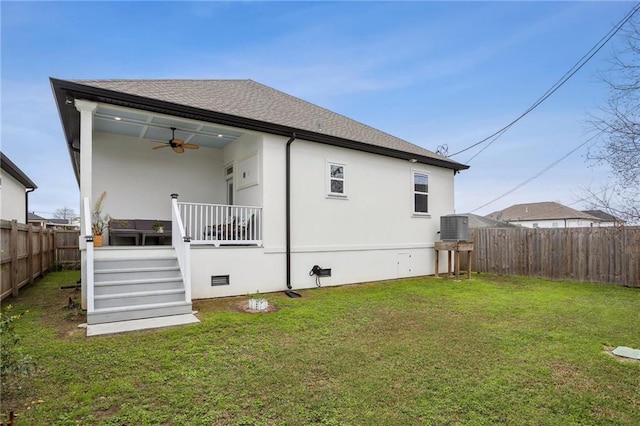 rear view of property with crawl space, a fenced backyard, a lawn, and a ceiling fan