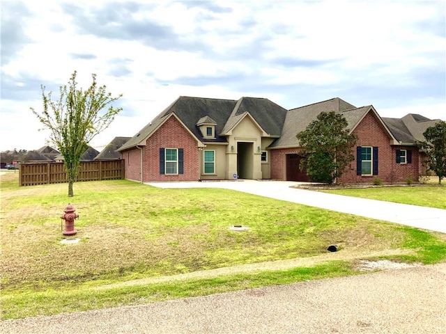 view of front of house with concrete driveway, brick siding, a front yard, and fence