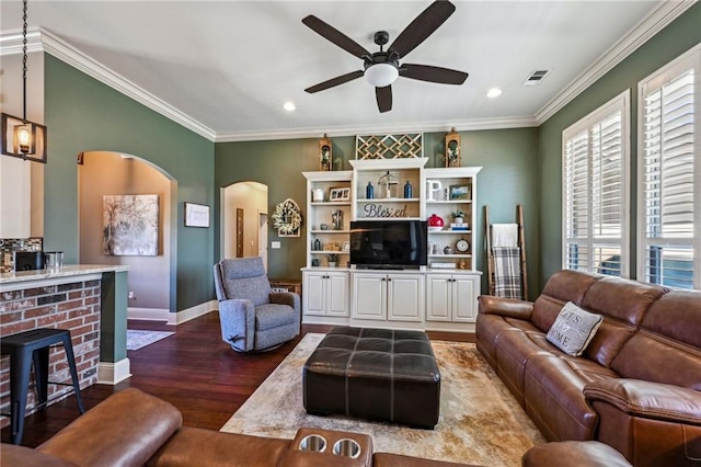 living room with arched walkways, crown molding, ceiling fan, and wood finished floors