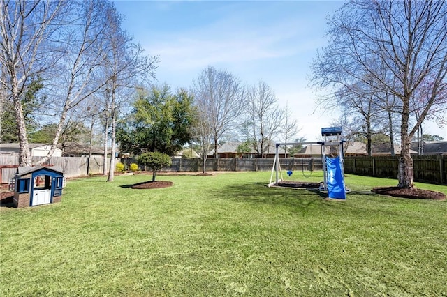 view of yard featuring playground community and a fenced backyard