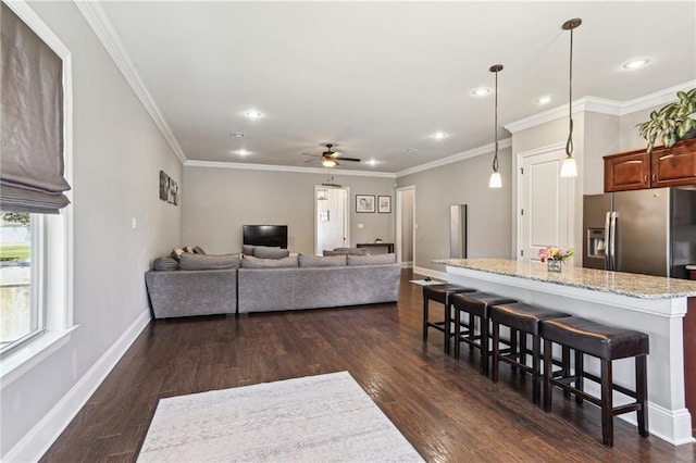 living room with dark wood-style floors, ceiling fan, ornamental molding, and baseboards