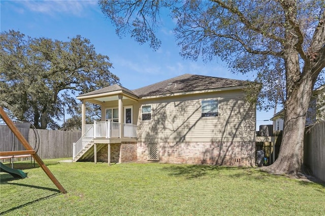 rear view of property with a fenced backyard, stairway, and a lawn