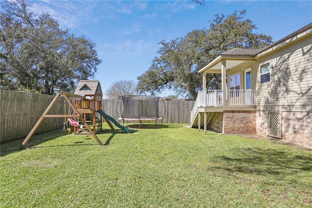 view of yard with a fenced backyard, a trampoline, a playground, and stairs