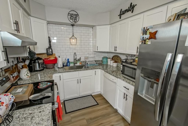 kitchen featuring stainless steel appliances, white cabinetry, a sink, light wood-type flooring, and under cabinet range hood