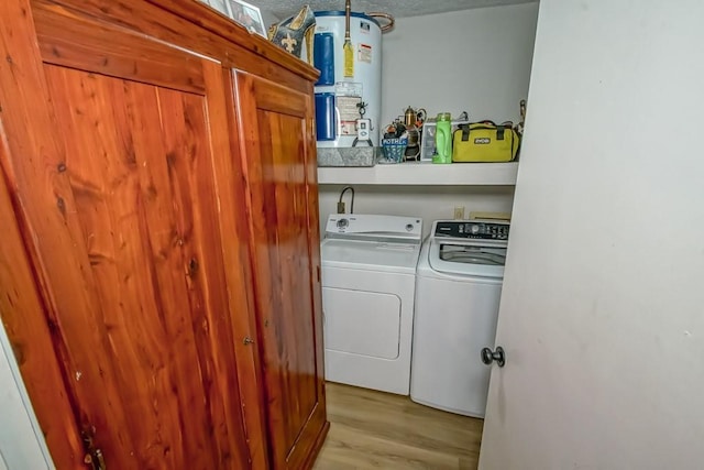 laundry area featuring water heater, laundry area, separate washer and dryer, and wood finished floors