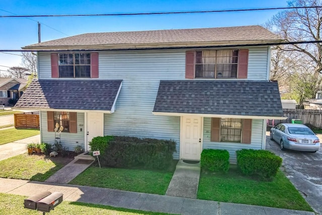 view of front of home featuring a shingled roof and fence