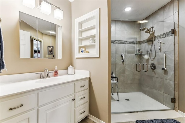 2243 E Canterbury Dr, La Place, LA 70068 - full bathroom featuring a stall shower, built in features, vanity, and baseboards