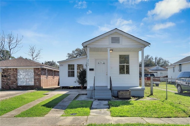 view of front facade with fence, an outbuilding, and a front yard