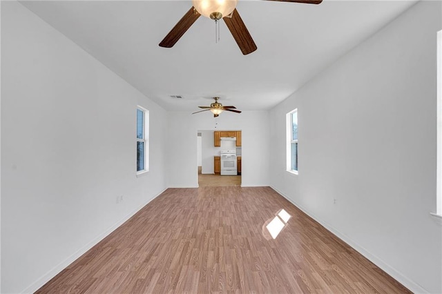 unfurnished living room with visible vents, light wood-style flooring, and baseboards