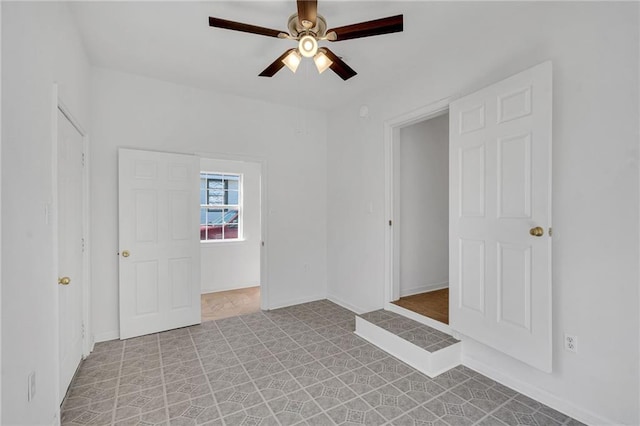 empty room featuring baseboards and a ceiling fan