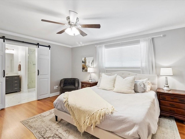 bedroom with light wood finished floors, a barn door, and crown molding