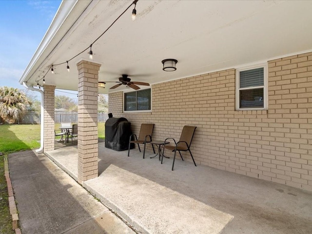 view of patio featuring fence, outdoor dining area, a ceiling fan, and area for grilling