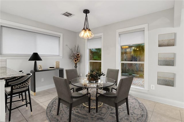 dining area with light tile patterned floors, baseboards, and visible vents