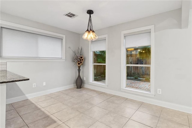 unfurnished dining area with light tile patterned floors, baseboards, and visible vents