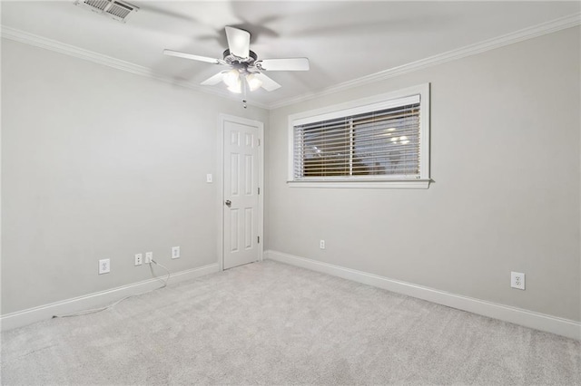 spare room featuring carpet floors, baseboards, visible vents, and crown molding