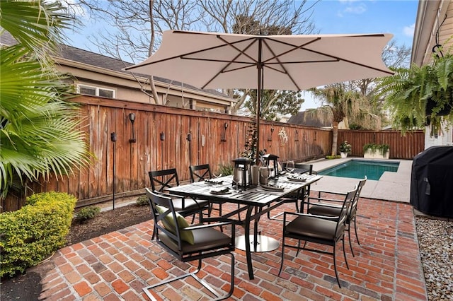 view of patio / terrace featuring a fenced backyard, a grill, outdoor dining area, and a fenced in pool