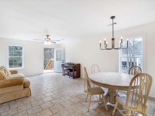 dining room featuring light tile patterned floors, baseboards, visible vents, and ceiling fan with notable chandelier