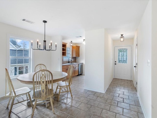 dining space with a chandelier, a healthy amount of sunlight, visible vents, and baseboards