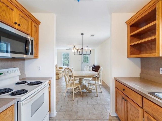 kitchen with visible vents, electric stove, light countertops, brown cabinetry, and stainless steel microwave